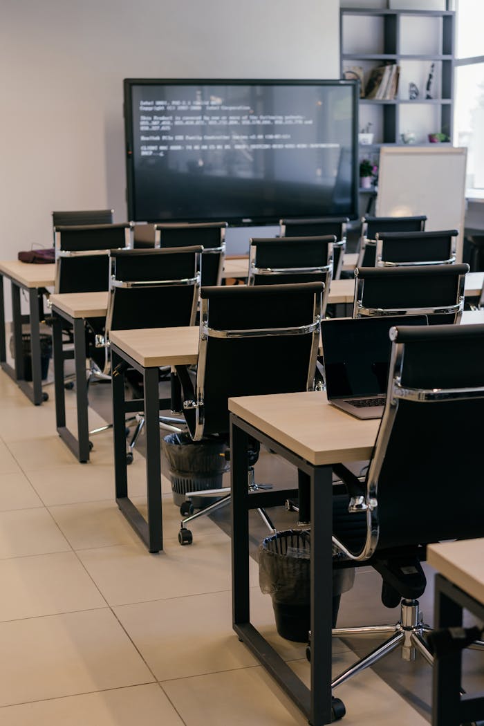 gallery-06 Contemporary office space with sleek black leather chairs and a large screen for presentations.